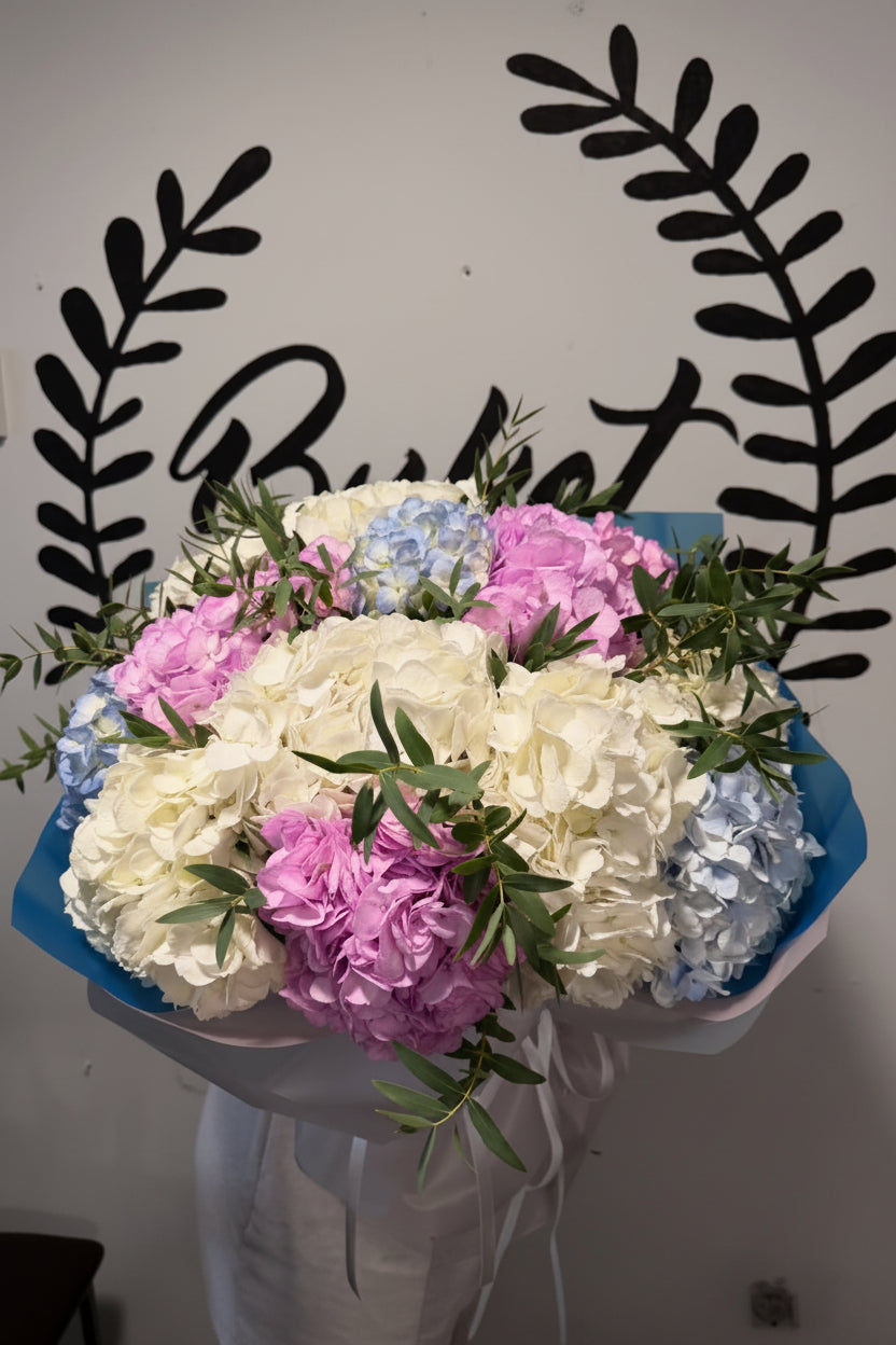 White pink and blue hydrangea bouquet with eucalyptus in blue wrap