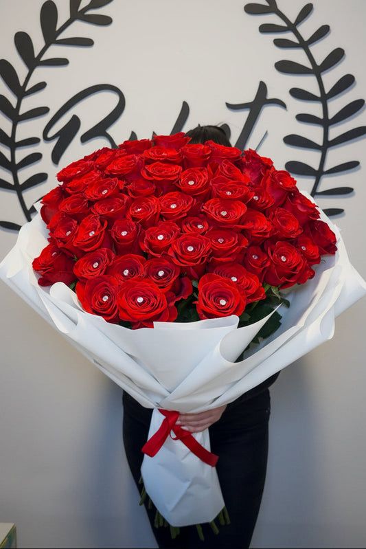 Red roses with crystal diamonds bouquet in white wrap