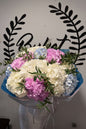 White pink and blue hydrangea bouquet with eucalyptus in blue wrap